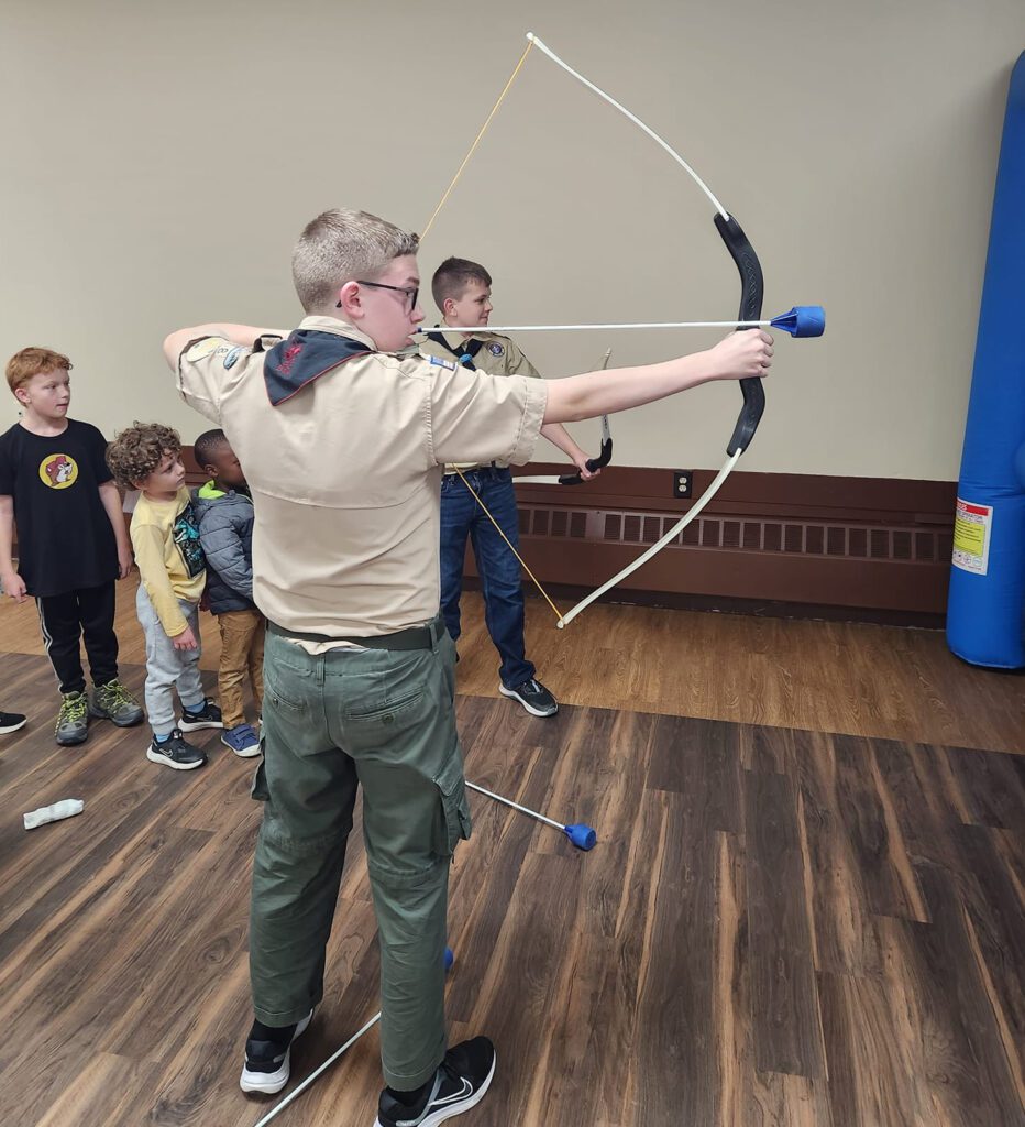 Boy Scout teaches Archery Fundamentals to future scouts.